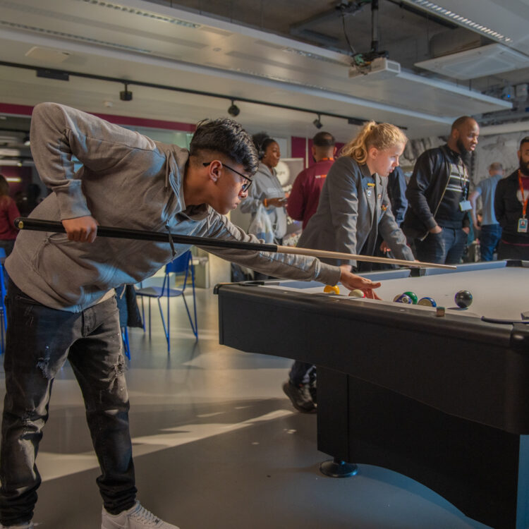 Young person playing pool in Spotlight Games Room
